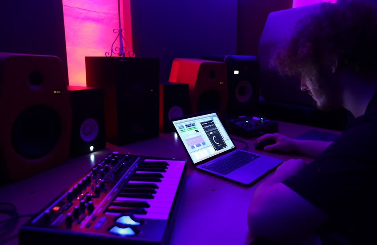 A studio desk with monitors and a DAW session open